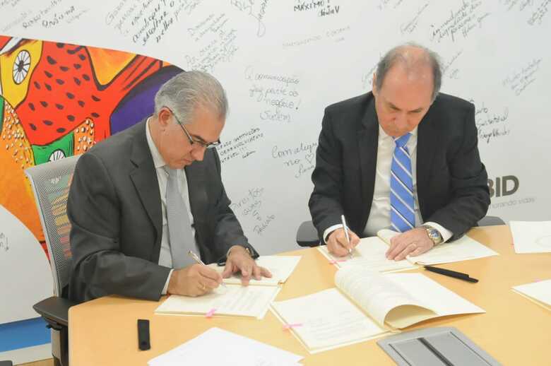 Governador Reinaldo Azambuja, assinando contrato com o diretor executivo do BID, Hugo Florez Timoran