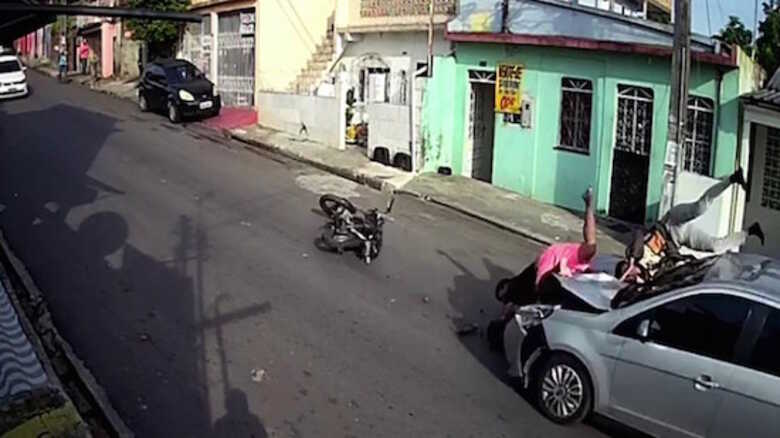 As imagens gravadas por câmeras de monitoramento mostram a dupla sendo atropelada e ficando em cima do capô do carro