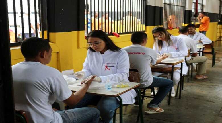 Agentes de sa&uacute;de realizando testes r&aacute;pidos de sangue