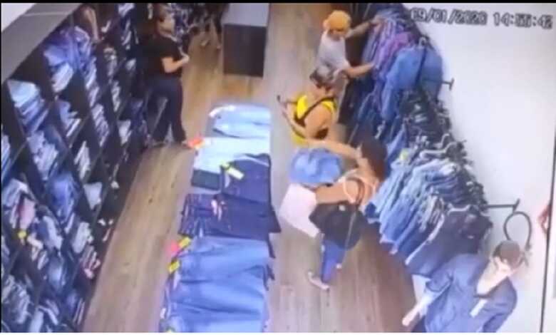 A mulher pega uma peça de roupa e coloca em sua sacola
