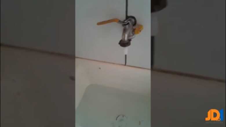 Moradora mostra falta de água nas torneiras
