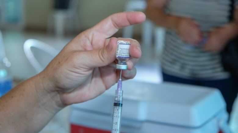Profissional da área da saúde preparando a vacina para aplicação